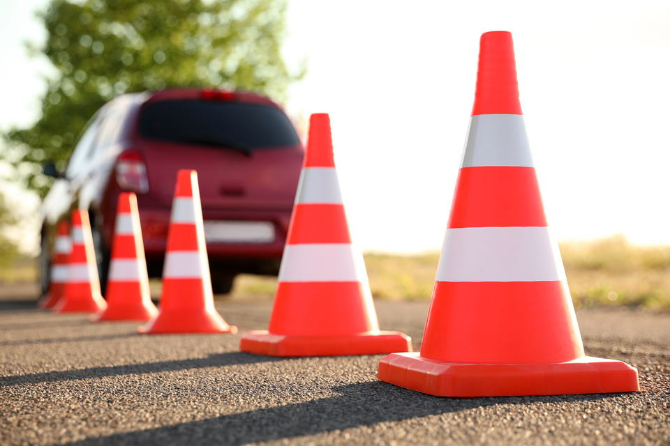 Conos de tráfico en línea con un coche al fondo